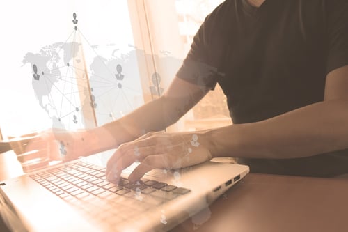 Close up of business man hand working on laptop computer with social media diagram and chart graph on wooden desk as concept